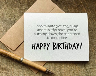 Pode incluir: Um cartão de felicitações branco com texto em preto que diz: one minute you're young and fun. the next, you're turning down the car stereo to see better. HAPPY BIRTHDAY! O cartão vem com um envelope castanho e uma caneta de madeira.