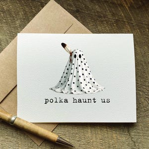 cute halloween greeting card with a play on words that says "polka haunt us" and features a polka dot ghost with a feather