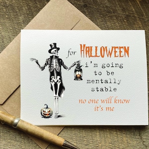May include: A white greeting card featuring a skeleton wearing a top hat and tailcoat, holding a lantern with a glowing pumpkin inside. The text reads: for HALLOWEEN i'm going to be mentally stable no one will know it's me in orange and black.