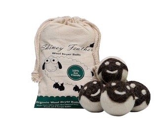 May include: A set of six organic wool dryer balls with a drawstring bag. The bag is beige and features a sheep illustration and the text "Shiney Feather Wool Dryer Balls". The dryer balls are white with dark brown accents.