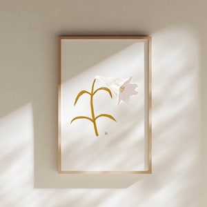 May include: A framed print of a white flower with a yellow stem and leaves. The flower is stylized and has a pink hue. The print is on a white background.