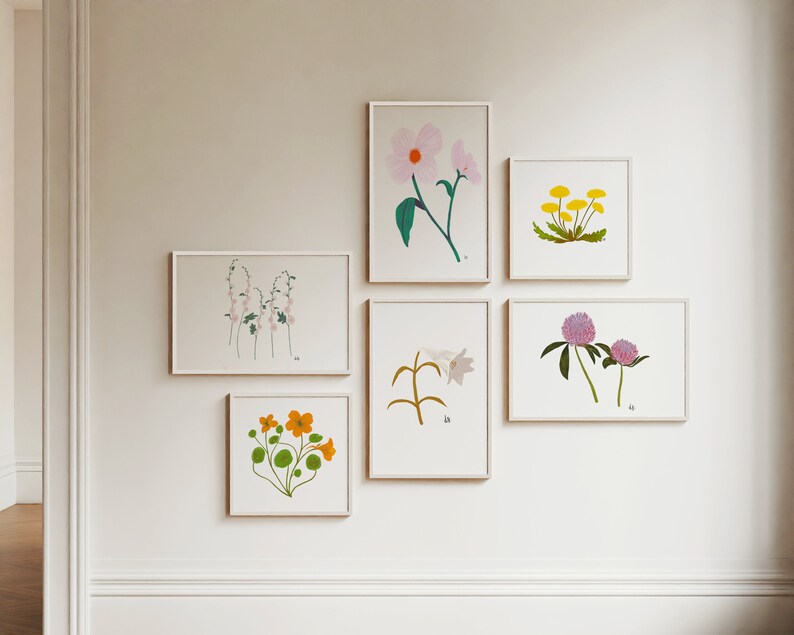 May include: A gallery wall with six framed botanical prints featuring various flowers and plants. The prints are in white frames and are arranged in a symmetrical pattern on a white wall.