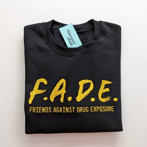 May include: Black sweatshirt with the text "F.A.D.E. FRIENDS AGAINST DRUG EXPOSURE" in yellow lettering.