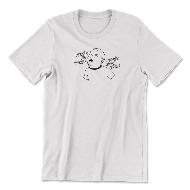 May include: White t-shirt with a black and white cartoon image of a person saying "That's my purse, I don't know you!"