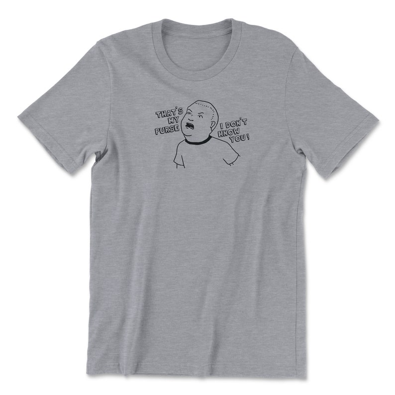 May include: A heather grey t-shirt with a black and white cartoon image of a person saying "That's my purse! I don't know you!"
