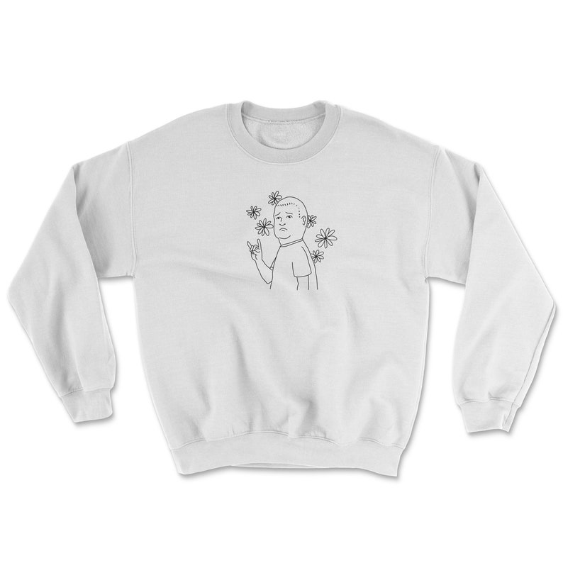 May include: White sweatshirt with a black line drawing of a cartoon character with flowers around their head. The character is making a rock and roll hand gesture.