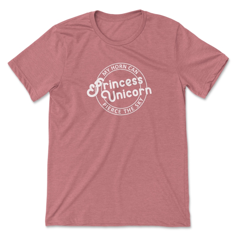 May include: A heather pink t-shirt with a white circle graphic that says "My horn can pierce the sky" and "Princess Unicorn" in a stylised font.