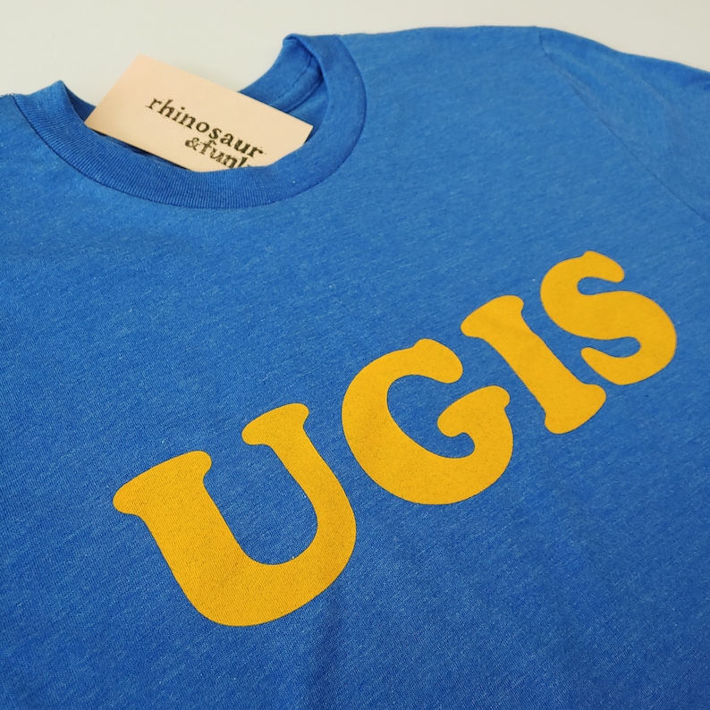 May include: A royal blue t-shirt with a yellow graphic that says "UGIS".