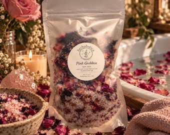 May include: A clear plastic pouch of Pink Goddess bath salts featuring a round white label with the text Herbaholicz, Pink Goddess, bath salts, made with red rose, hibiscus and Himalayan pink salt, net wt. 4 oz. The pouch contains a mixture of salt crystals and dried flower petals.
