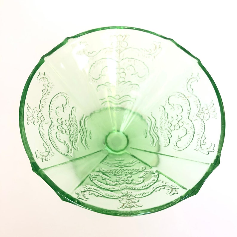 May include: A green glass bowl with a scalloped rim and an etched floral design.
