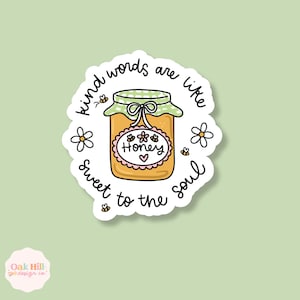 May include: A sticker with a jar of honey illustration. The jar has a green and white checkered lid and a pink label with the word "Honey" and a heart. The text "Kind words are like sweet to the soul" surrounds the jar.