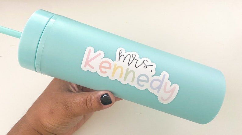 Peut inclure: Un gobelet bleu clair avec une paille assortie. Le gobelet porte un autocollant avec l'inscription "mrs. Kennedy" dans des couleurs pastel. Cette gourde r&eacute;utilisable est con&ccedil;ue pour les boissons froides.