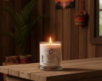 May include: A clear glass jar candle with a white wax fill and a lit wick. The label features the text Fran Charms, Caribbean Teakwood, Hard Poured Soy Candle. The candle sits on a wooden surface, emitting a warm glow from the flame.