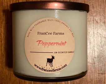 May include: A white candle jar with a brown lid. The label says "FranCee Farms Peppermint Unscented Candle" and includes a goat silhouette. The label also says "Made with Fragrance Oils 100% Organic Soy Wax" and "www.franceefarms.com Handpoured".
