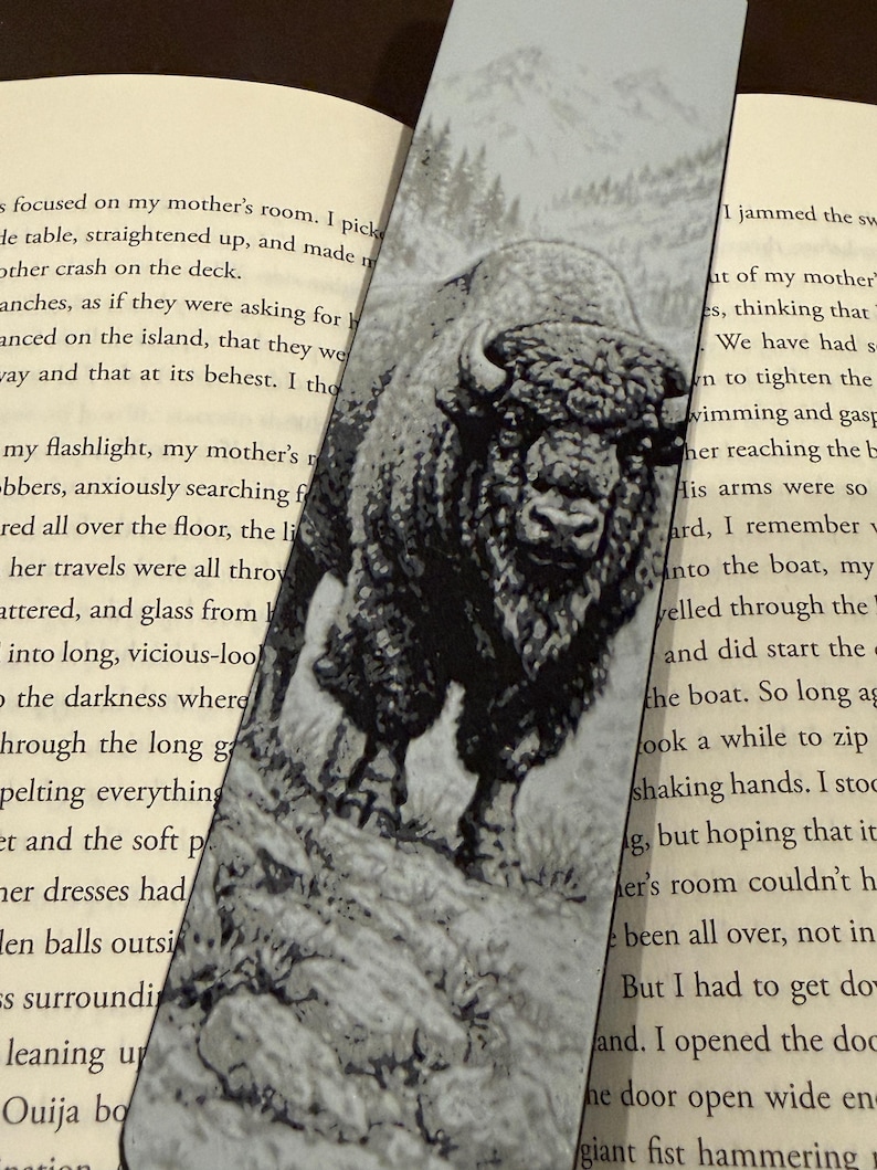 Puede incluir: Marcap&aacute;ginas en blanco y negro con una ilustraci&oacute;n detallada de un bisonte sobre una superficie rocosa. La imagen tiene una est&eacute;tica vintage, con una cordillera al fondo. Un accesorio para los amantes de la lectura.