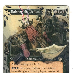 May include: A black and white Magic: The Gathering card featuring a zombie dwarf creature with a red beard and a sword. The card text reads "Balthor the Defiled" and "All Minions get +1/+1.  , Remove Balthor the Defiled from the game: Each player returns all black and all red creature cards from his or her graveyard to play. He remembers enough of his life to weep for what he has lost."