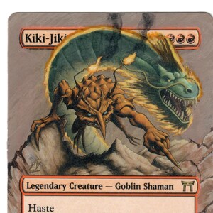May include: A Magic: The Gathering card featuring Kiki-Jiki, Mirror Breaker, a legendary goblin shaman creature with haste. The card art depicts a goblin-like creature with a dragon-like creature behind it. The card text reads: "Haste. : Put a creature token into play that's a copy of target nonlegendary creature you control. That creature token has haste. Sacrifice it at end of turn. 2/2."