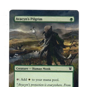 May include: A Magic: The Gathering card featuring a green and white illustration of a human monk holding a staff with a glowing orb. The card is titled "Avacyn's Pilgrim" and has the text "Creature - Human Monk" and "1/1".