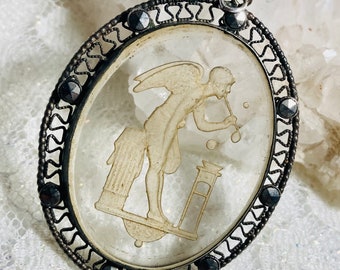 Antique carved glass & marcasite pendant. Boy angel blowing bubbles. Collectors item.