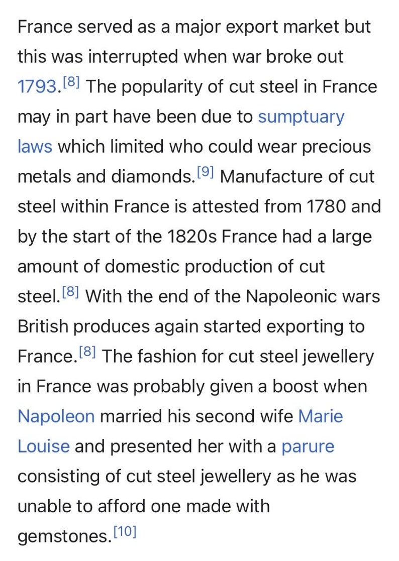 May include: A text excerpt from a book about the history of cut steel jewelry in France. The text mentions the popularity of cut steel jewelry in France, sumptuary laws, and the role of Napoleon in promoting the fashion.