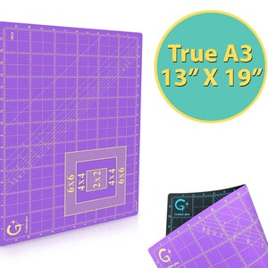 May include: Purple self-healing cutting mat with a grid pattern and measurements in inches. The mat has a black border and a white G+ Golden Plus logo. The mat is labeled "True A3 13" x 19"".