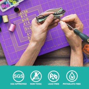 May include: A close-up of a person making a bracelet with colorful threads on a purple cutting mat. The bracelet has a charm that says "LOVE". The image also shows various safety certifications, including SGS Approved, Non-Toxic, Lead-Free, and Phthalate-Free.