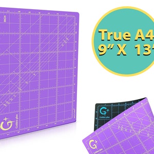 May include: A purple self-healing cutting mat with a grid pattern and measurements in inches. The mat is labeled "Golden Plus" and is 9 inches by 13 inches. The text "True A4" is written in a circle.