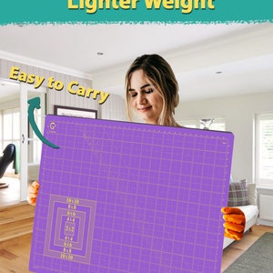 May include: A purple self-healing cutting mat with a grid pattern and measurements in inches. The mat is 10 inches by 10 inches and has a grid pattern with measurements in inches. The mat is being held by a person.