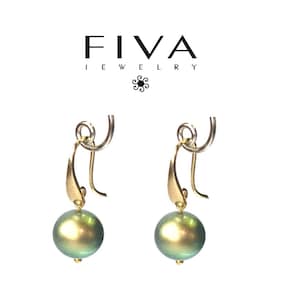 Pode incluir: Um par de brincos dourados com pérolas verdes iridescentes. Os brincos têm um design curvo com uma pequena conta dourada na parte inferior de cada pérola. A marca "FIVA JEWELRY" é exibida no topo.