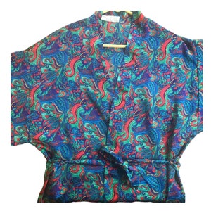 May include: A blue, green, red, and yellow patterned silk robe with a V-neck and a tie belt.