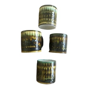 May include: Set of four ceramic mugs with a green, brown, and white geometric pattern.