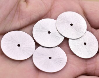May include: Five silver watch dials with a sunburst pattern and a small hole in the centre.
