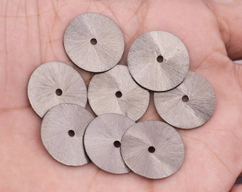 May include: Eight silver watch dials with a sunburst pattern and a small hole in the center.