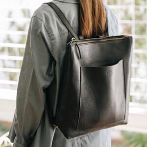 Woman from side wearing black leather convertible tote backpack, handmade full grain vegetable tanned leather
