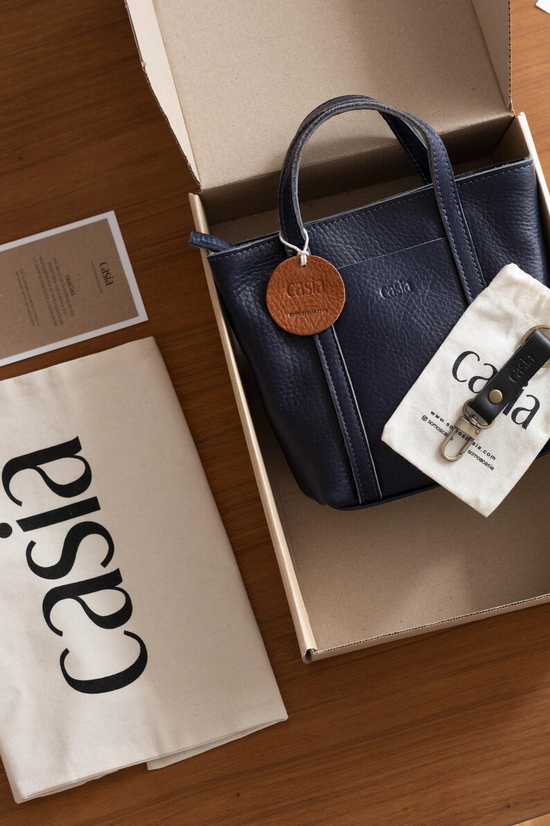 Casia navy leather bag inside gift packaging box with brand materials