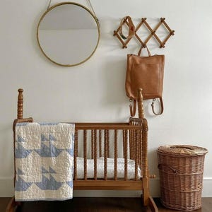 Caramel leather convertible backpack next to baby crib, handmade full grain leather diaper bag for mom