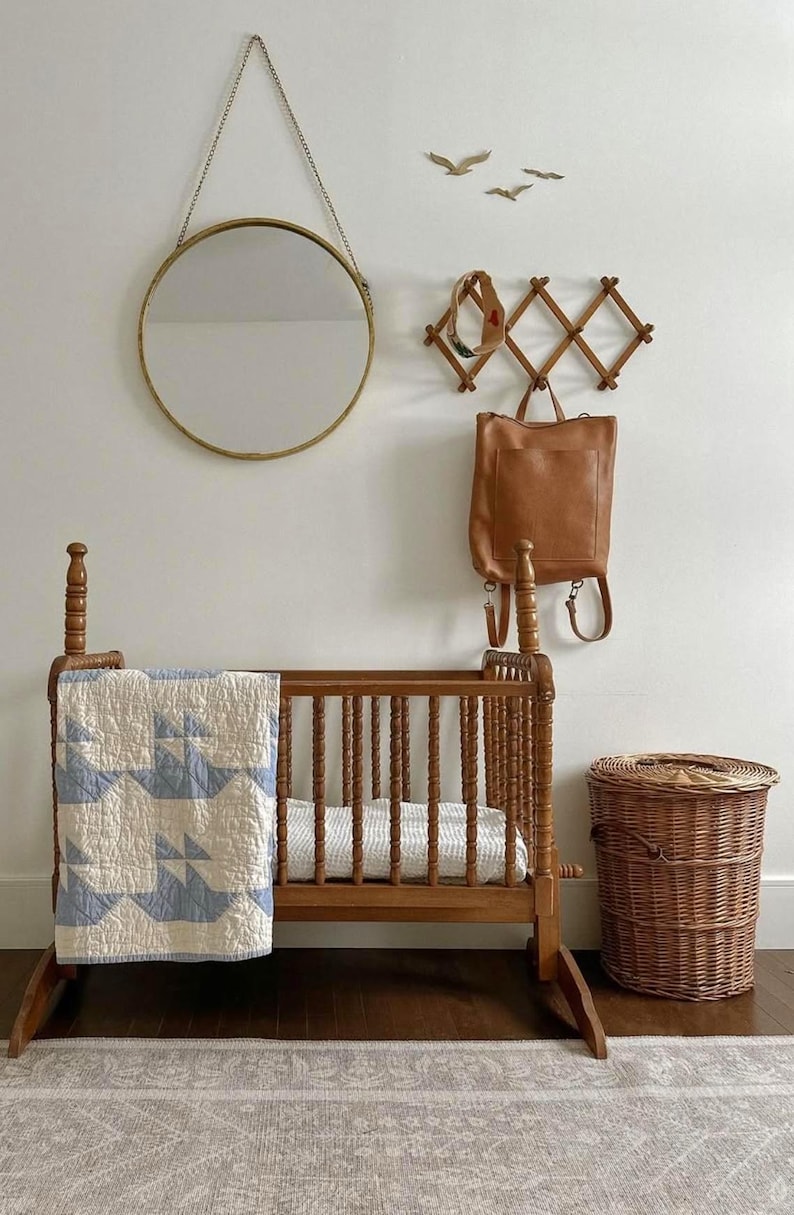 Caramel leather convertible backpack next to baby crib, handmade full grain leather diaper bag for mom