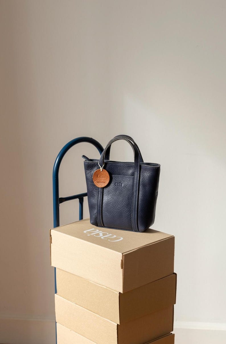 Navy leather bags stacked on wooden boxes showing depth and structure