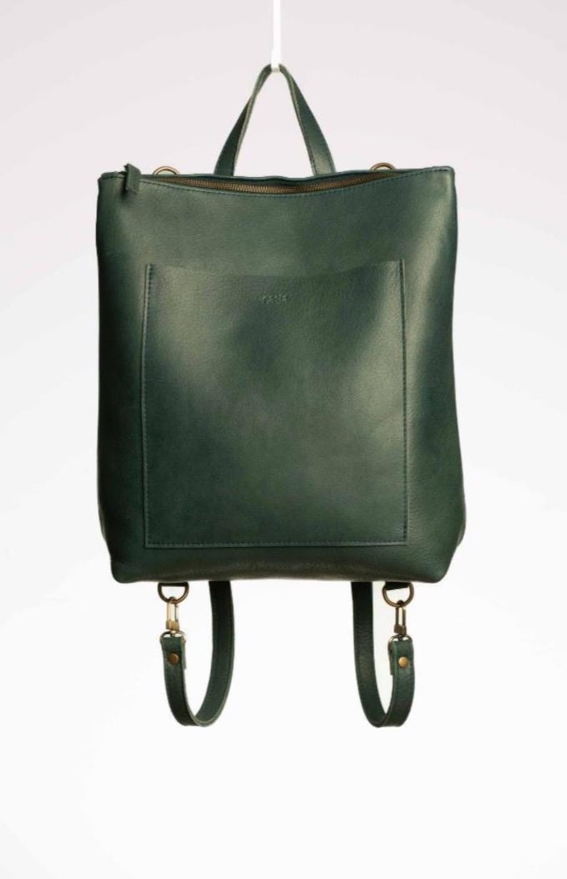 Green full grain leather convertible backpack front view on white background, handmade leather rucksack