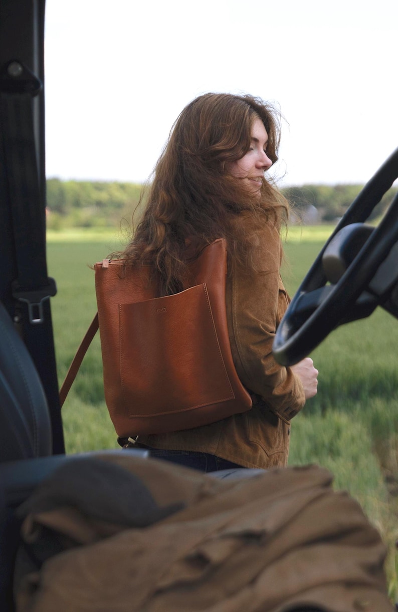 Woman outdoors with caramel leather convertible backpack, full grain vegetable tanned leather bag for women