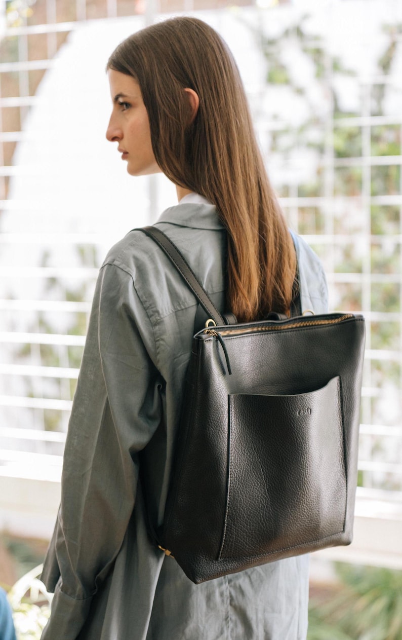 Woman from side wearing black leather convertible tote backpack, handmade full grain vegetable tanned leather