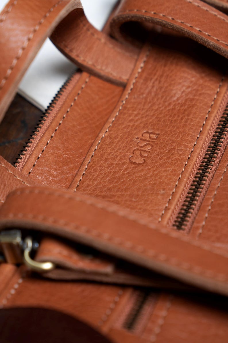 Close up of caramel leather backpack stitching and zipper detail, handmade full grain vegetable tanned leather