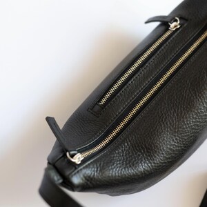 Close up of black full grain leather banana bag showing gold zipper detail and natural leather texture, vegetable tanned cowhide handmade crossbody
