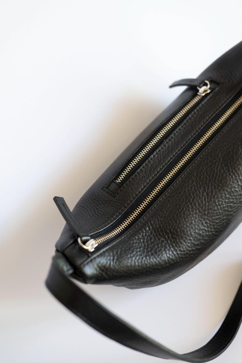 Close up of black full grain leather banana bag showing gold zipper detail and natural leather texture, vegetable tanned cowhide handmade crossbody
