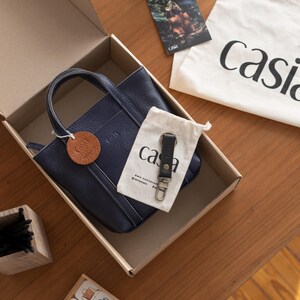 Casia leather bag inside gift packaging box with brand materials
