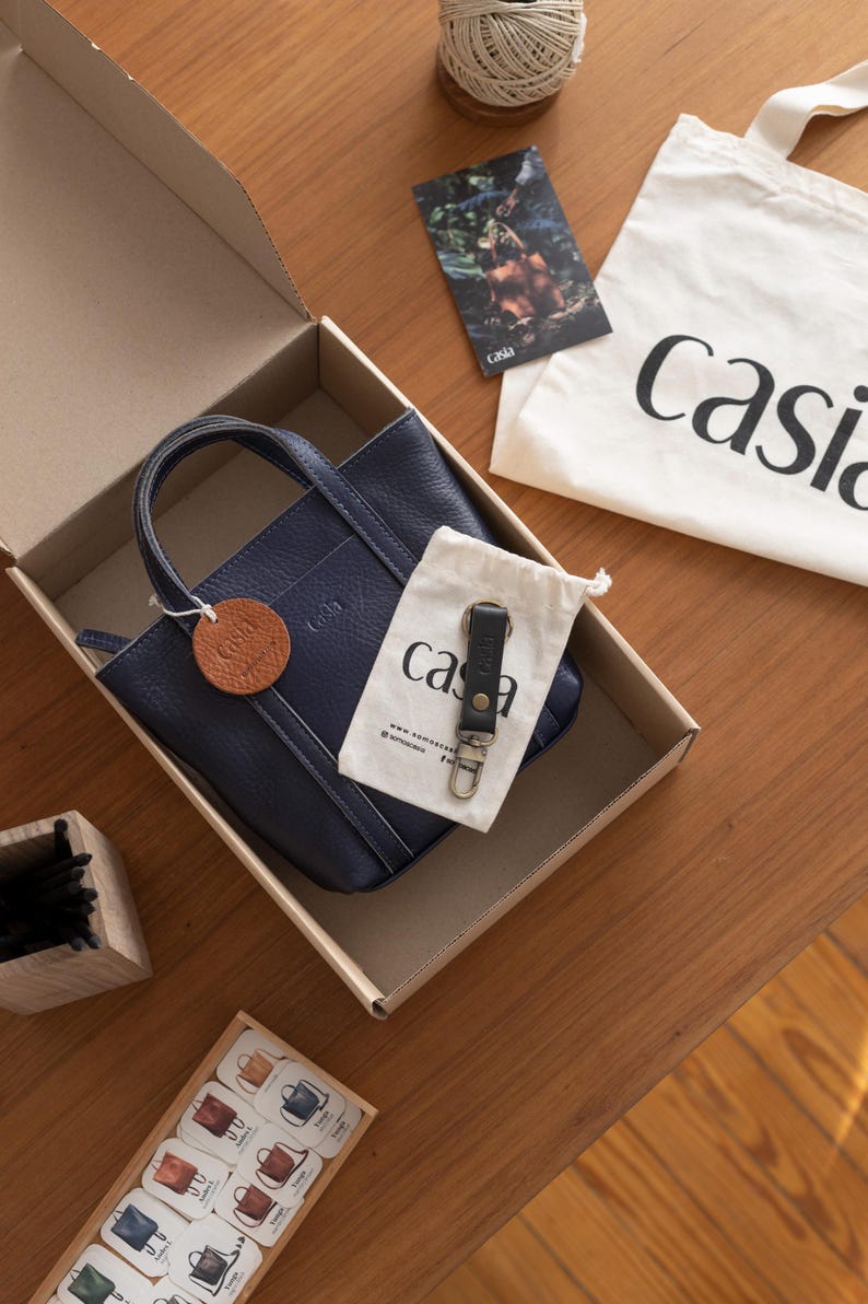 Casia leather bag inside gift packaging box with brand materials