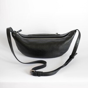 Black full grain leather banana bag on white background, moon shape vegetable tanned crossbody sling bag, handmade leather belt bag product shot