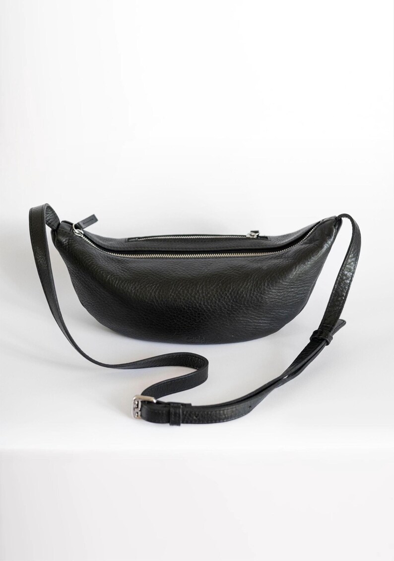 Black full grain leather banana bag on white background, moon shape vegetable tanned crossbody sling bag, handmade leather belt bag product shot