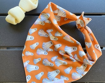 May include: Orange bandana with a white ghost pattern and the text "mostly sunny" on the bottom right corner.