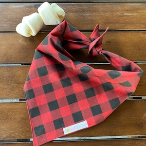 May include: Red and black buffalo plaid dog bandana with a white label that says "muttly amazing".